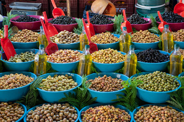 Green and black olives at food market different type of olives with organic pressed olive oil