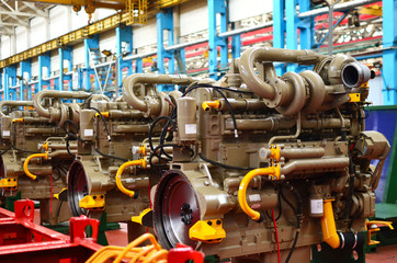 Diesel engines with huge turbines on assembly line in the workshop of the factory for the production of large mining trucks. Warning, small roughness sharpness, possible granularity.