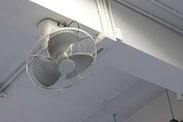 White fan mounted on the beam. Wall mounted fans mounted on top.