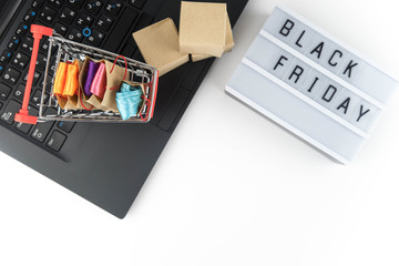 Shopping cart with purchases - packages and boxes on the modern laptop. Online shopping, black friday and sale concept.