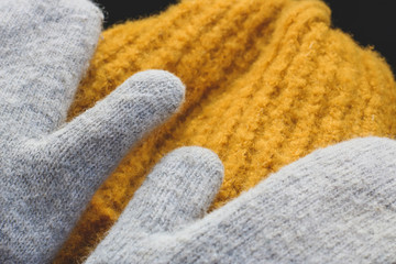 Warm winter clothes. Knitted mittens and hat in trendy mustard color