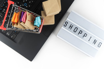 Shopping cart with purchases - packages and boxes on the modern laptop. Online shopping, black friday and sale concept.
