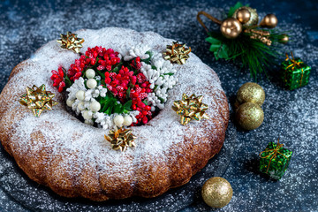 Christmas, holiday muffin sprinkled with powdered sugar. Decorated with New Year's toys. On a dark background. Copy space. 