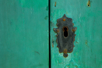 Detail of a historic green door with a black keyhole in Paraty-Mirim, Rio de Janeiro, Brazil