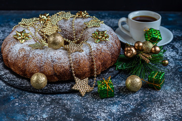 Christmas, holiday muffin sprinkled with powdered sugar. Decorated with New Year's toys. On a dark background. Copy space. 