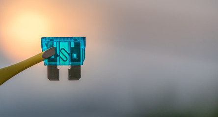 Automotive blade fuse on road background