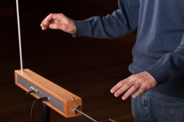 Man plays the thereminvox - an electric musical instrument