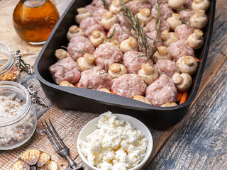 Delicious homemade food. Turkey meat mince balls with champignons, carrots, spices and herbs in a cast iron baking dish. Close-up
