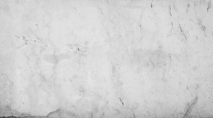 Close-up of an aged and cracked smooth natural marble stone wall or flooring. High resolution full frame textured background in black and white.