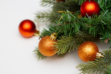 Fototapeta na wymiar Spruce paws with gold christmas balls on white background