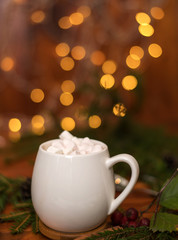 Cacao drink in a white cup with marshmallow on the background of bokeh lights, Hot Christmas drink