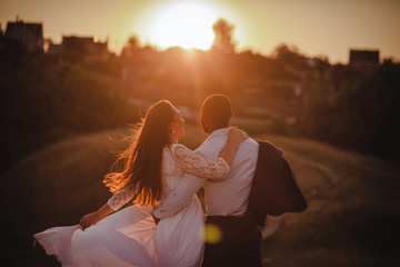 Lovely mixed couple is watching the sunset