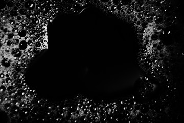 Beautiful abstract foam white bubbles on dark black background and soap black bubble and detergent