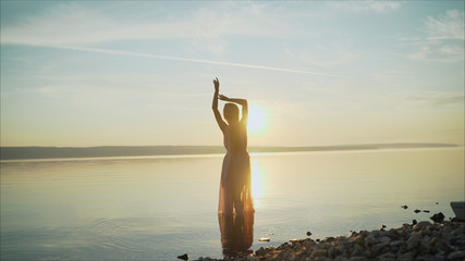 silhouette of a dancing girl on a background sunset. beautiful girl dancing and having fun...