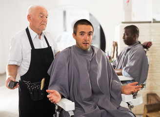 Man unpleasantly surprised by haircut from elderly hairdresser