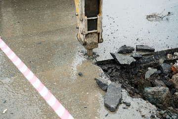 Repair of communications located under the carriageway. Road repair car breaks asphalt.
