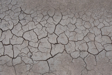 Texture of dry crackled soil dirt or earth during drought.