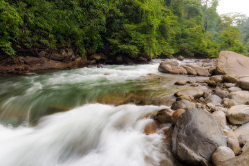 Beautiful landscape view of the a river in the rainforest during a ecotourism jungle hike in Gunung Leuser National Park, Bukit Lawang, Sumatra, Indonesia