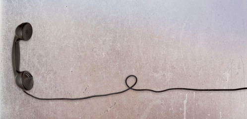 A black vintage dial telephone handset with metal background.	