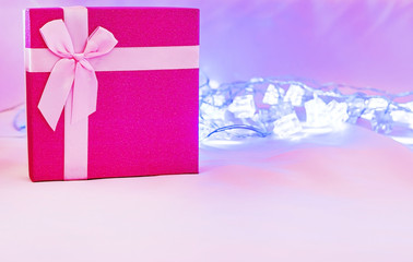 Red gift box with pink ribbon isolated on pink background. 