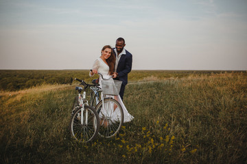 Fototapeta premium african american man and european woman riding bikes in the field