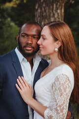 happy and beautiful mixed ethnicity couple with beautiful afro American man and cheerful europian woman loking in different directions