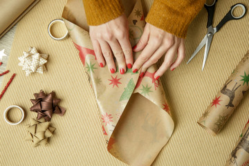 Woman wrapping Christmas presents, winter hoildays,  gifting season concept