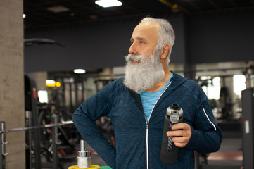 Fit bearded senior man resting after working out.