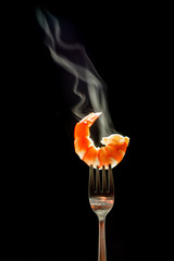 shrimp on the fork with dark background. shrimp with steam and smoke on fork close up.selective focus tiger shrimp on silver fork,  food concept