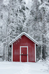 The house in the forest has covered with heavy snow and bad sky in winter season at Holiday Village Kuukiuru, Finland.