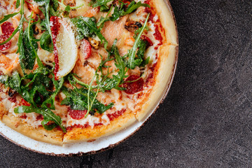 Traditional Italian pizza on a dark background top view copy space.