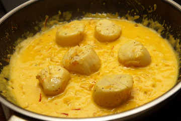 scallops with saffron saucein a pan