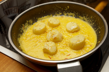 scallops with saffron saucein a pan