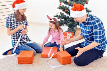 Holidays and presents concept - Portrait of a happy family opening gifts at Christmas time