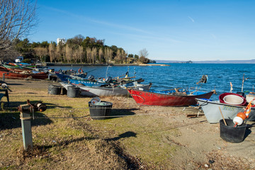 Fototapeta na wymiar Traditional fishing net and boats, beach of Marta, little town on Bolsena lake, Viterbo, Lazio, Italy.