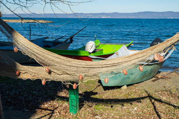 Traditional fishing net and boats, beach of Marta, little town on Bolsena lake, Viterbo, Lazio,...