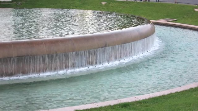 Tight shot over a round water source in a park, in Paris, France