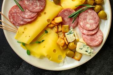 cheese board (different types of cheese plate appetizers , sausage, ham, olives, greens and more) menu concept. food background. copy space. Top view