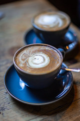 Cups of coffee on a wooden table, with a shallow depth of field