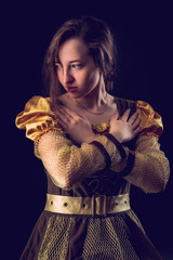 Portrait of an attractive girl princess on a dark background, vintage toned photo