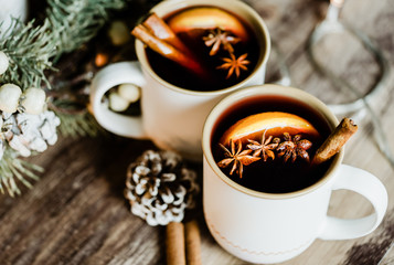 Mulled wine in white rustic mugs with spices, cinnamon and slide citrus fruit.Traditional hot drink...