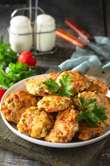 Chicken meatballs with minced meat with tomatoes in a bowl on a wooden rustic table.