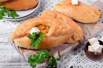 Rasstegai pie of yeast dough with meat filling on white wooden table. Traditional meal of Russian cuisine © kcuxen