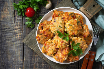 Chicken meatballs with minced meat with tomatoes in a bowl on a wooden rustic table. Top view flat lay background with copy space.