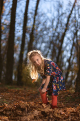 Amazing leaf. Cute girl in a big pile of foliage. Little child girl enjoy playing on fresh air