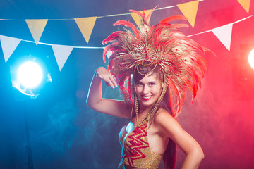 Fototapeta na wymiar Holidays, party, dance and nightlife concept - Beautiful woman dressed for carnival night