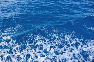 Blue sea water background and waves with sea foam