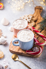 Obraz na płótnie Canvas Hot chocolate cacao drinks with marshmallows in Christmas color mugs on grey background. Traditional hot beverage, festive cocktail at X-mas or New Year