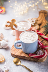 Hot chocolate cacao drinks with marshmallows in Christmas mugs on grey background. Traditional hot beverage, festive cocktail at X-mas or New Year