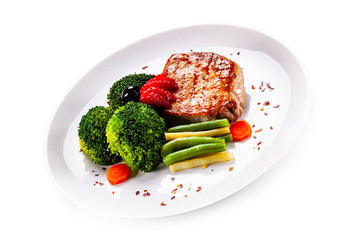Grilled steak with vegetables on white background